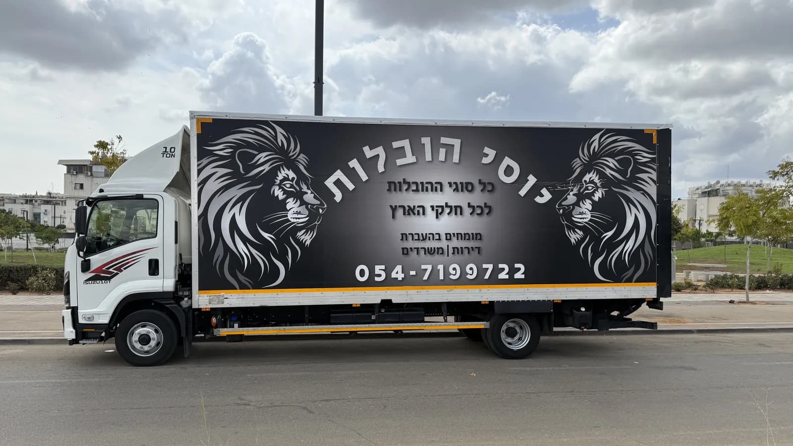 המשאית של יוסי הובלות מהצד, עם שני האריות, השם, ״כל סוגי ההובלות לכל חלקי הארץ״ ומספר הטלפון